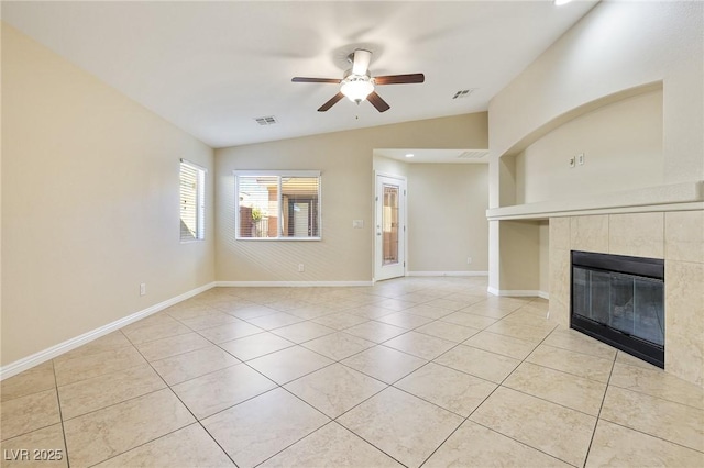 unfurnished living room featuring a tiled fireplace, ceiling fan, light tile patterned flooring, and lofted ceiling