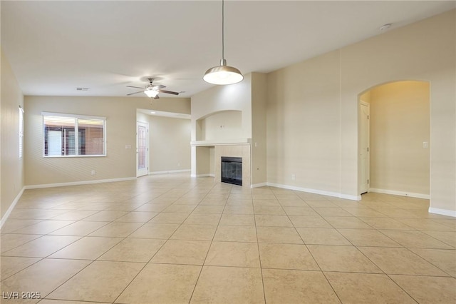 unfurnished living room with lofted ceiling, a tile fireplace, ceiling fan, and light tile patterned flooring