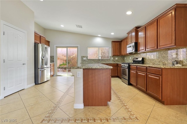 kitchen featuring stainless steel appliances, a kitchen island, lofted ceiling, and light stone counters