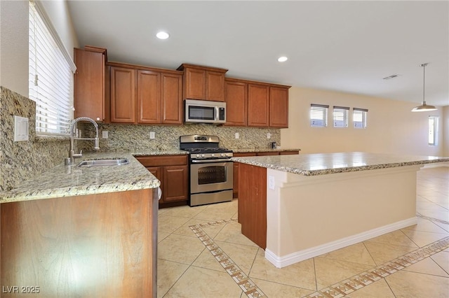 kitchen featuring a kitchen island, light tile patterned floors, hanging light fixtures, and appliances with stainless steel finishes