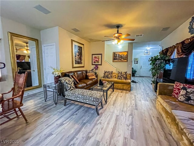 living room featuring visible vents, ceiling fan, and wood finished floors