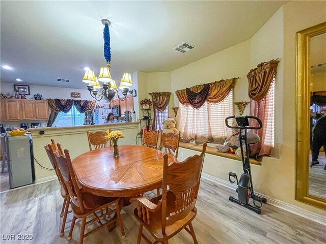 dining room featuring an inviting chandelier and light hardwood / wood-style flooring