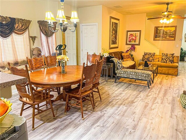 dining room with ceiling fan with notable chandelier and hardwood / wood-style floors