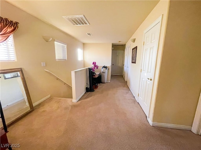 hallway featuring plenty of natural light and light colored carpet