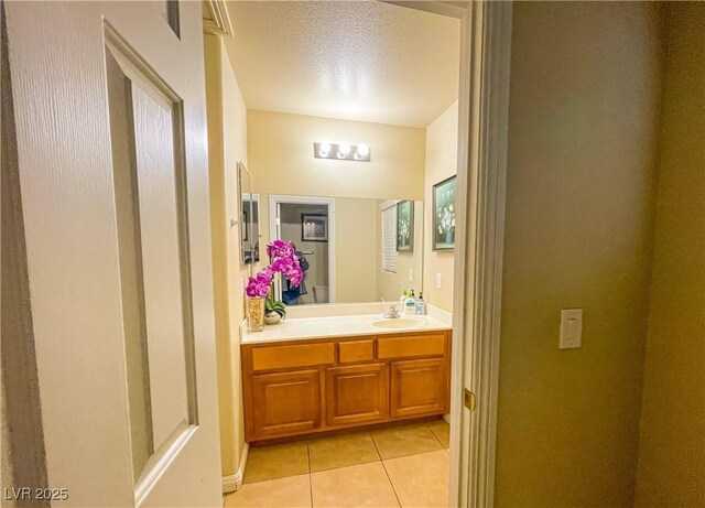 bathroom with vanity, toilet, tile patterned flooring, and a textured ceiling