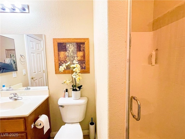 bathroom with vanity, an enclosed shower, and toilet