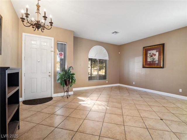 tiled entryway featuring an inviting chandelier