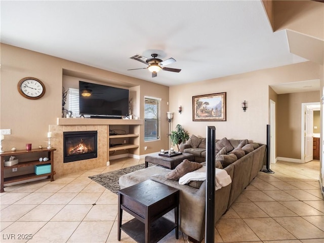 tiled living room featuring ceiling fan and a tiled fireplace