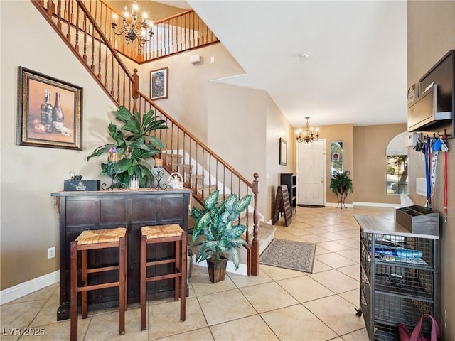 tiled foyer entrance featuring a chandelier