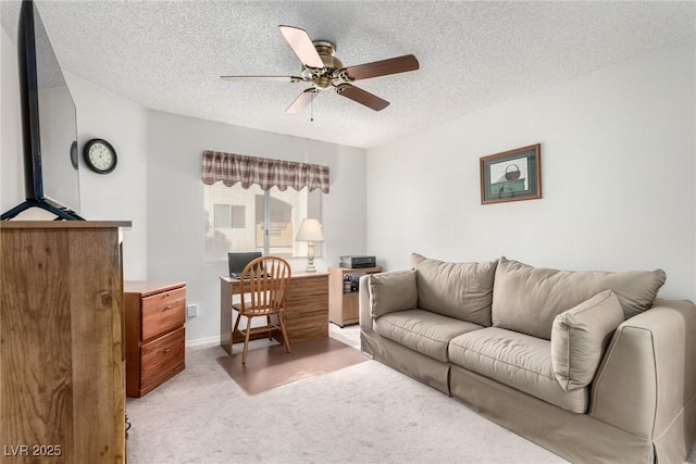 carpeted living room featuring ceiling fan and a textured ceiling