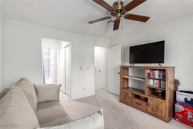 carpeted living room featuring a textured ceiling and ceiling fan