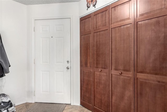 interior space featuring light tile patterned floors and a textured ceiling