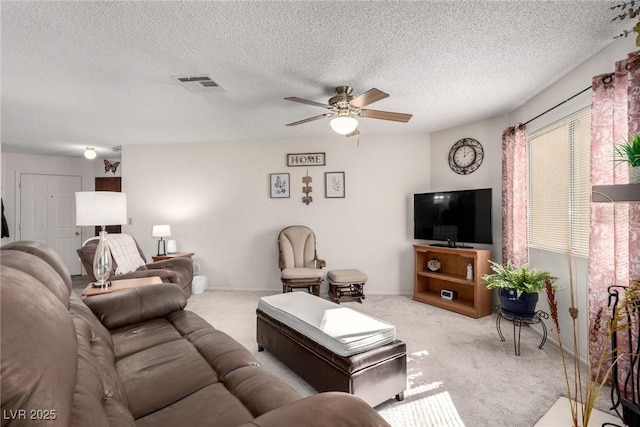 carpeted living room featuring a textured ceiling and ceiling fan