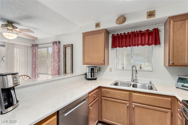 kitchen featuring ceiling fan, sink, stainless steel dishwasher, kitchen peninsula, and a textured ceiling