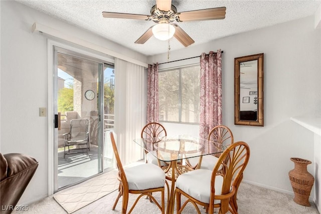 carpeted dining area featuring a textured ceiling and ceiling fan