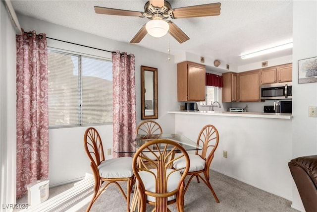 carpeted dining space featuring ceiling fan and a textured ceiling