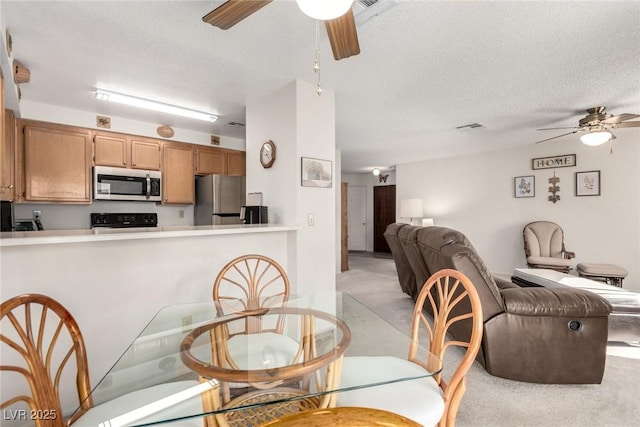 dining area with ceiling fan and a textured ceiling