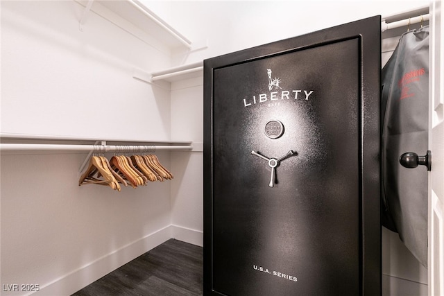 walk in closet with dark hardwood / wood-style floors