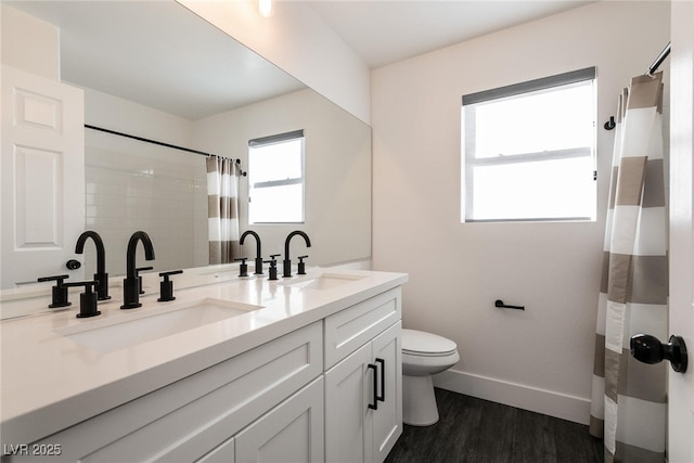 bathroom with toilet, wood-type flooring, vanity, and curtained shower