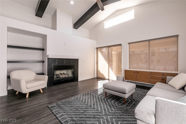 living room with a high ceiling, a fireplace, beam ceiling, and dark hardwood / wood-style floors