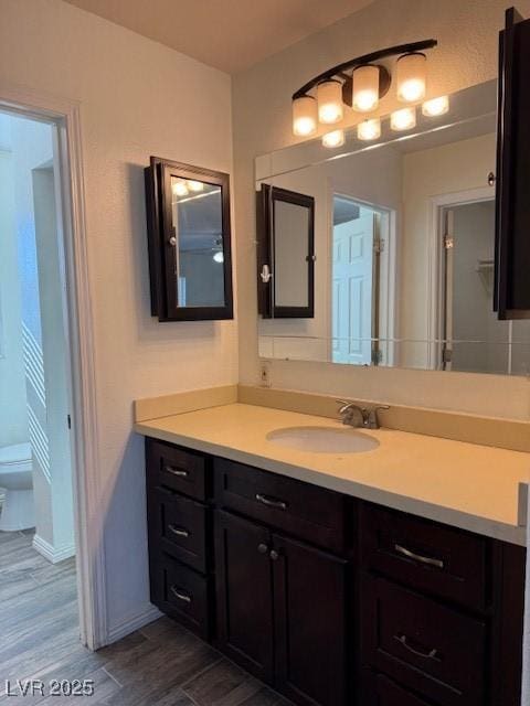 bathroom with hardwood / wood-style floors, vanity, and toilet