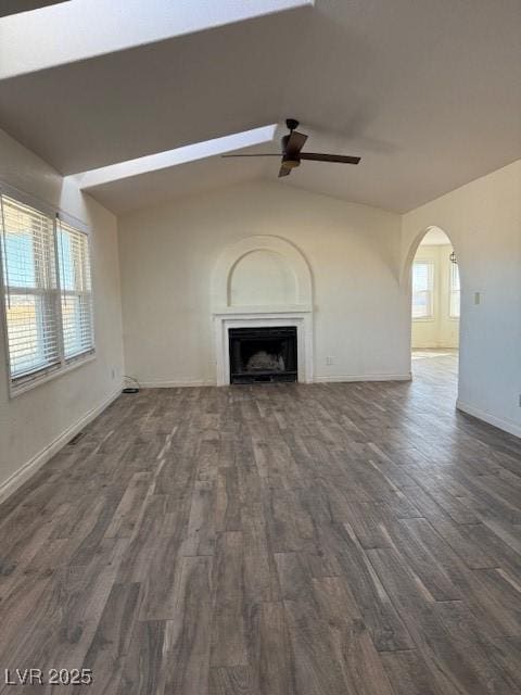 unfurnished living room featuring vaulted ceiling, ceiling fan, and dark wood-type flooring