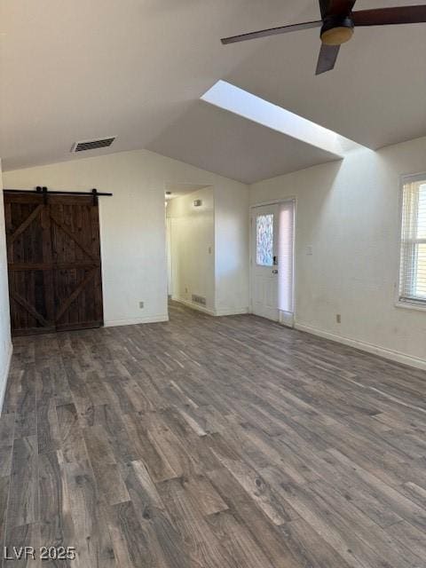 unfurnished living room featuring wood-type flooring, a barn door, ceiling fan, and lofted ceiling