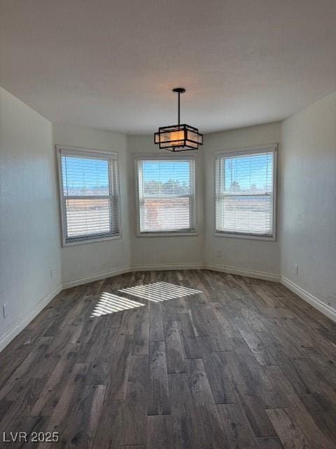 unfurnished dining area featuring dark wood-type flooring