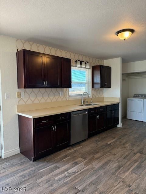 kitchen with dark brown cabinetry, washer and dryer, sink, and stainless steel dishwasher