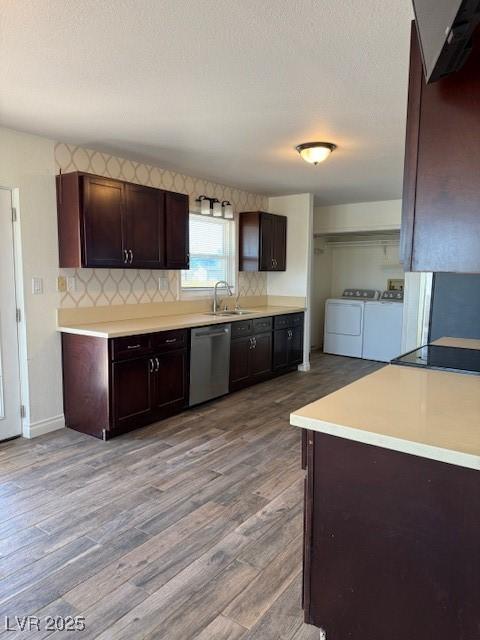 kitchen featuring sink, light hardwood / wood-style flooring, stainless steel dishwasher, washing machine and dryer, and dark brown cabinets