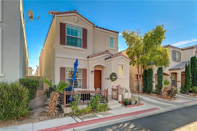 mediterranean / spanish home featuring a tile roof and stucco siding