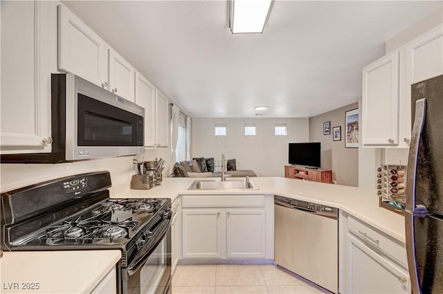 kitchen featuring white cabinetry, sink, black appliances, and kitchen peninsula