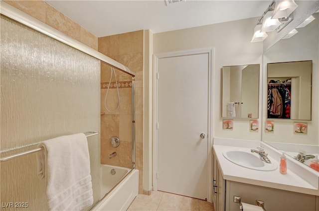 bathroom with tile patterned flooring, bath / shower combo with glass door, and vanity