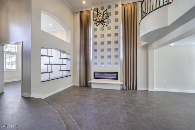 interior space featuring crown molding, a chandelier, and a high ceiling