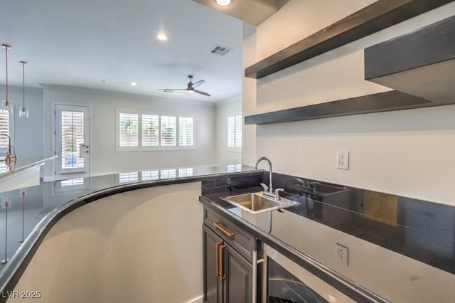 kitchen with hanging light fixtures, ceiling fan, crown molding, and sink