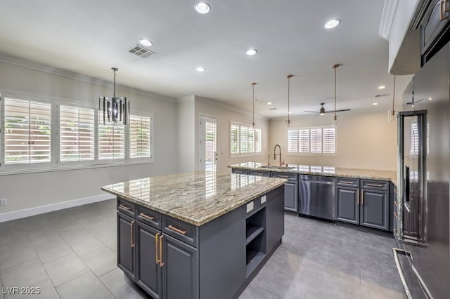 kitchen with pendant lighting, a kitchen island, light stone countertops, and stainless steel appliances