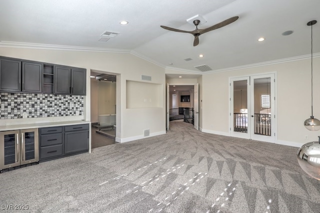 unfurnished living room featuring ceiling fan, beverage cooler, crown molding, lofted ceiling, and carpet