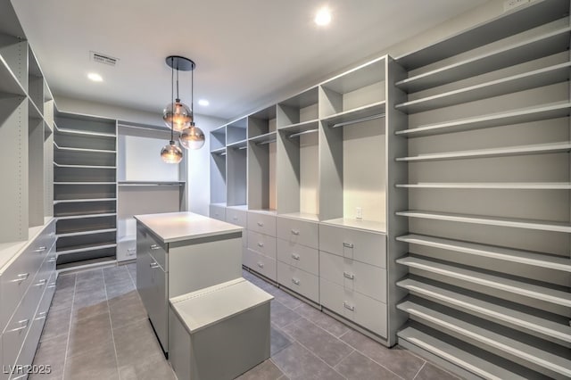 walk in closet with dark tile patterned floors