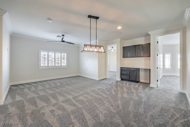 interior space with dark brown cabinetry, ceiling fan, carpet, and ornamental molding