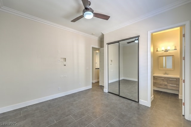 unfurnished bedroom featuring ceiling fan, dark tile patterned floors, ornamental molding, connected bathroom, and a closet