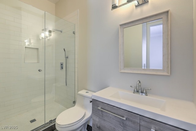 bathroom featuring vanity, an enclosed shower, and toilet