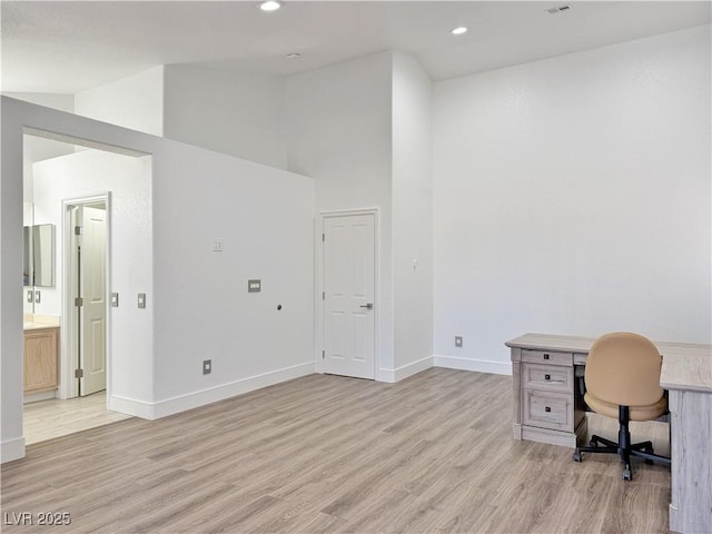 office with lofted ceiling and light hardwood / wood-style flooring