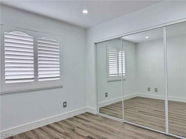 unfurnished bedroom with hardwood / wood-style floors and a closet