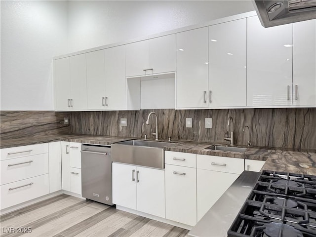 kitchen with white cabinetry, stainless steel dishwasher, sink, and light wood-type flooring