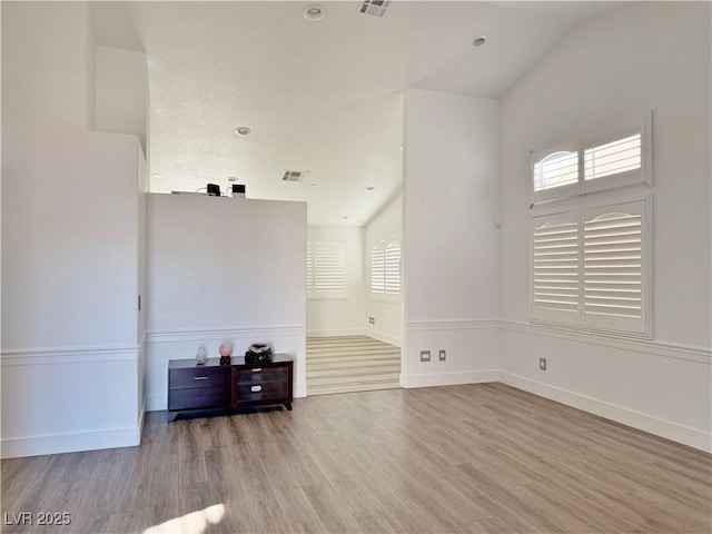 unfurnished living room featuring vaulted ceiling and wood-type flooring