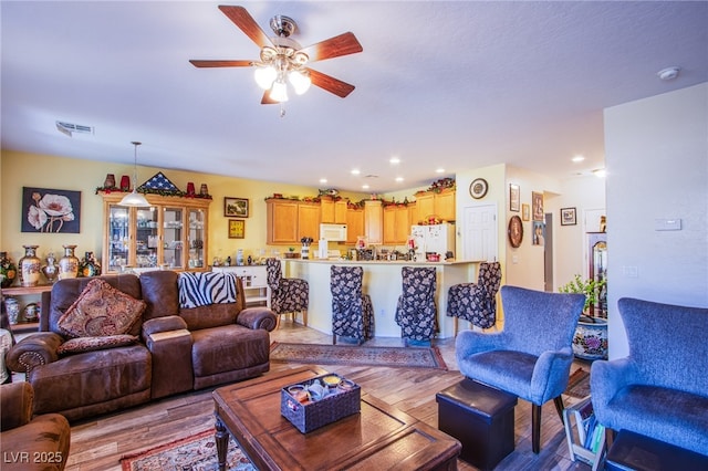 living room featuring ceiling fan and light hardwood / wood-style flooring