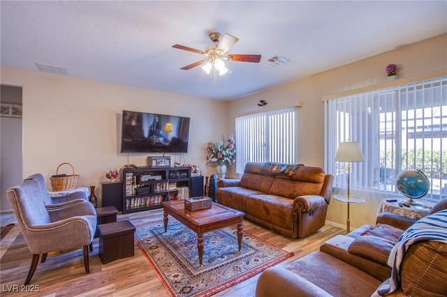 living room with ceiling fan, a wealth of natural light, and light wood-type flooring