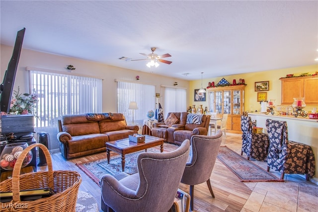 living room with light hardwood / wood-style floors and ceiling fan