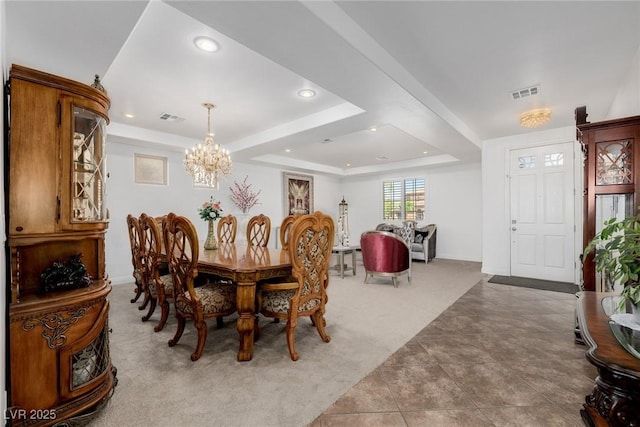 carpeted dining room featuring a raised ceiling and a chandelier