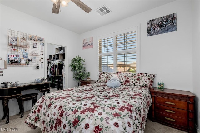 carpeted bedroom with ceiling fan, a spacious closet, and a closet